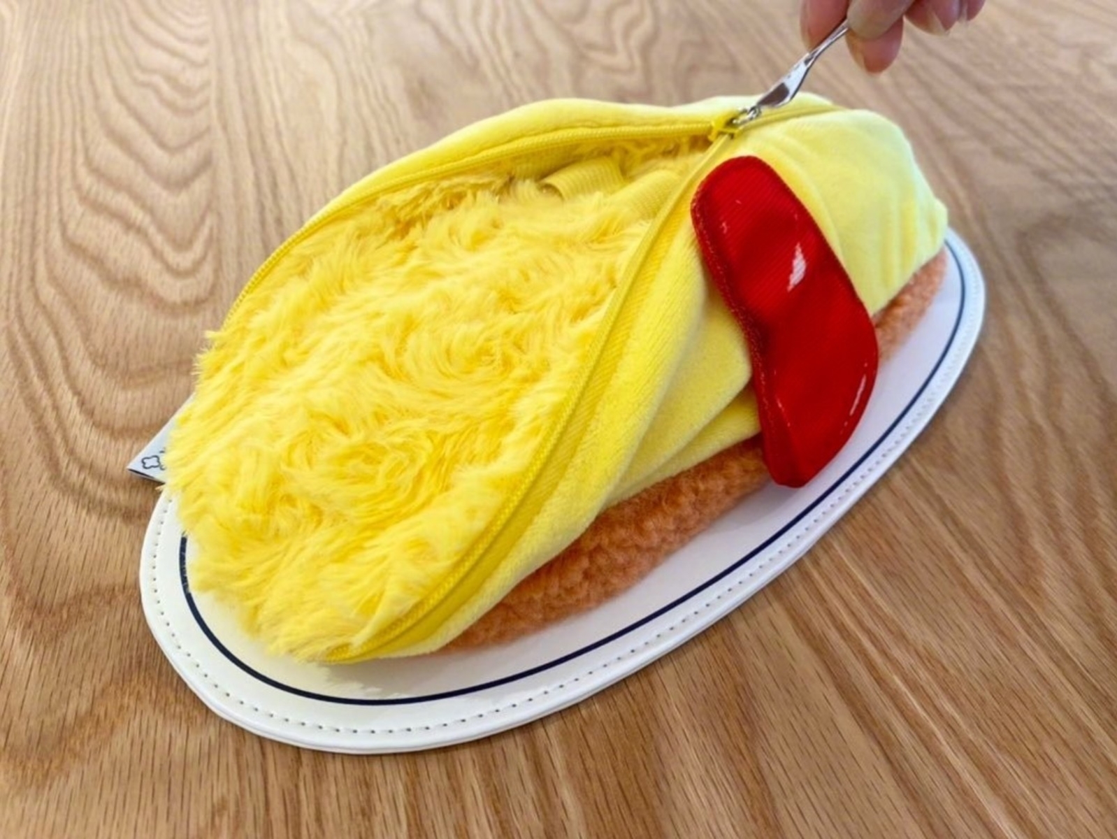 日本搞怪推出「蛋包飯收納包」，一拉開來秒變流心歐姆蛋～
