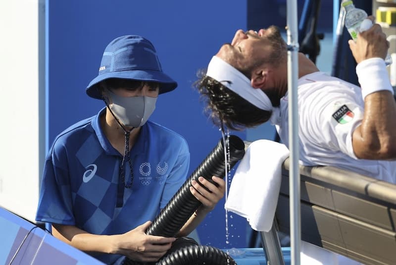 球僮正拿著冷氣管吹著一位義大利網球球員
