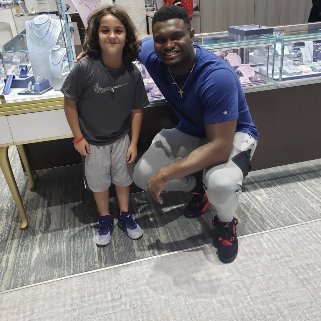 Zion Williamson 與穿著自己簽名鞋的小孩合照