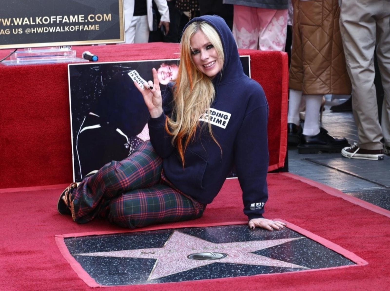 艾薇兒 Avril Lavigne 出道 21 年終於名留好萊塢星光大道，「穿上 16 歲同款帽 T」躺地上興奮合影！